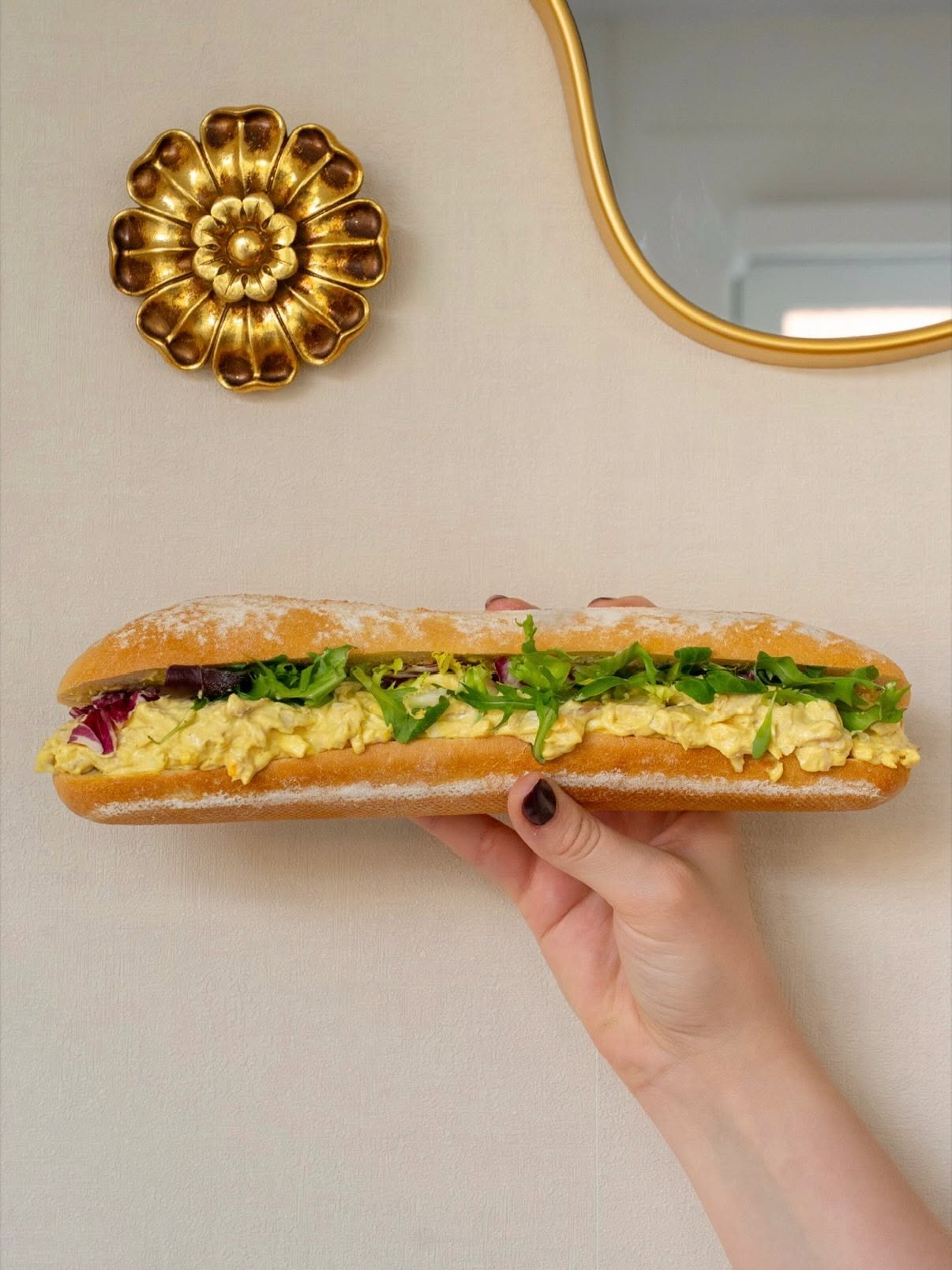 Sandwich poulet curry tenu à la main